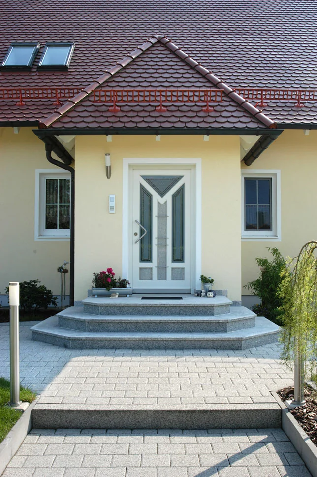 Weiße Haustür unter einem Vordach an einem Einfamilienhaus